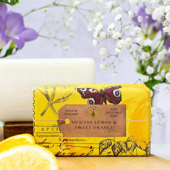 tvål Sicilian lemon & sweet orange på 200g från Saponi med blommor i bakgrunden.